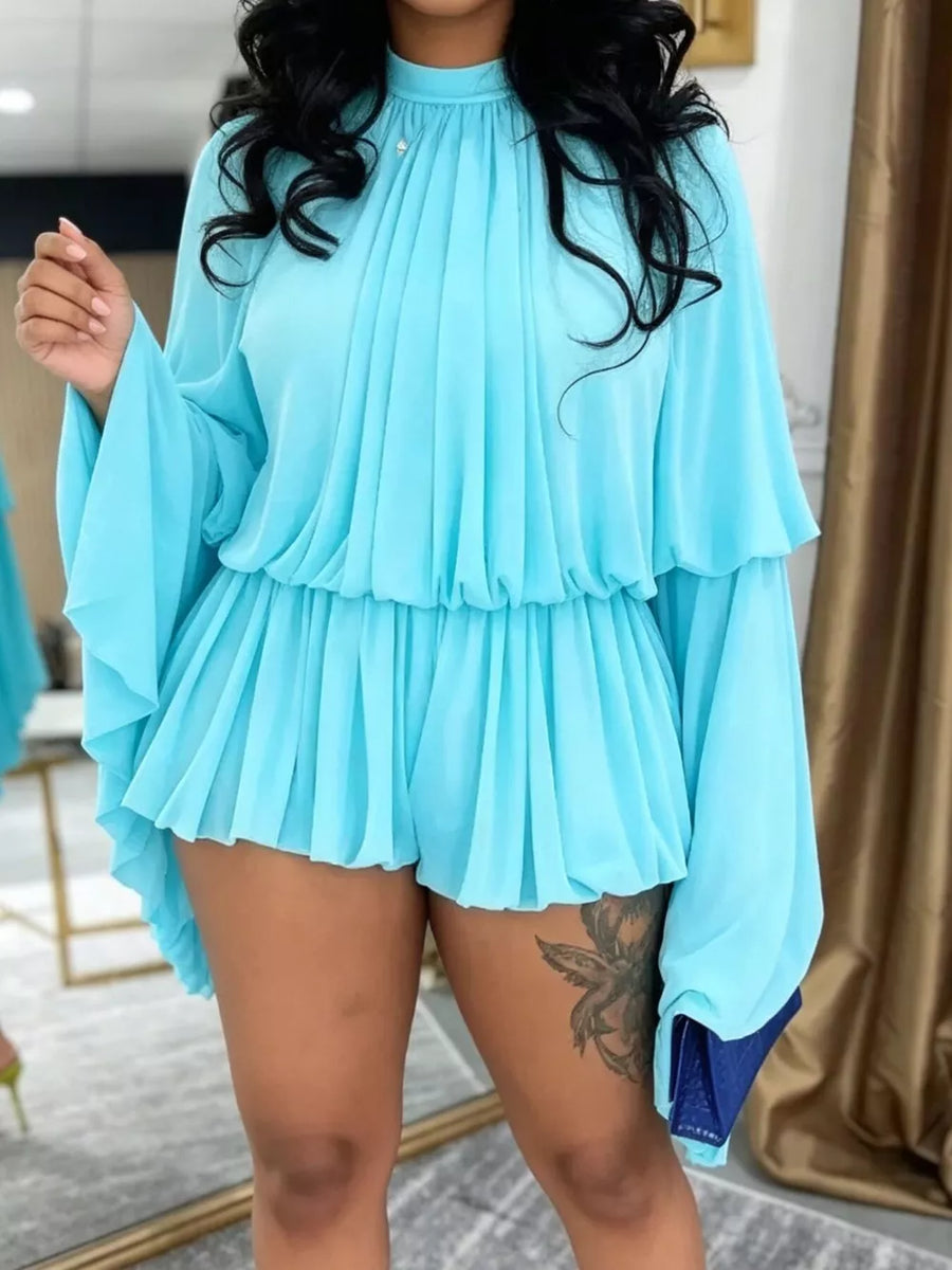 Light blue chiffon romper with high neck, tiered bell sleeves, and ruffled shorts.