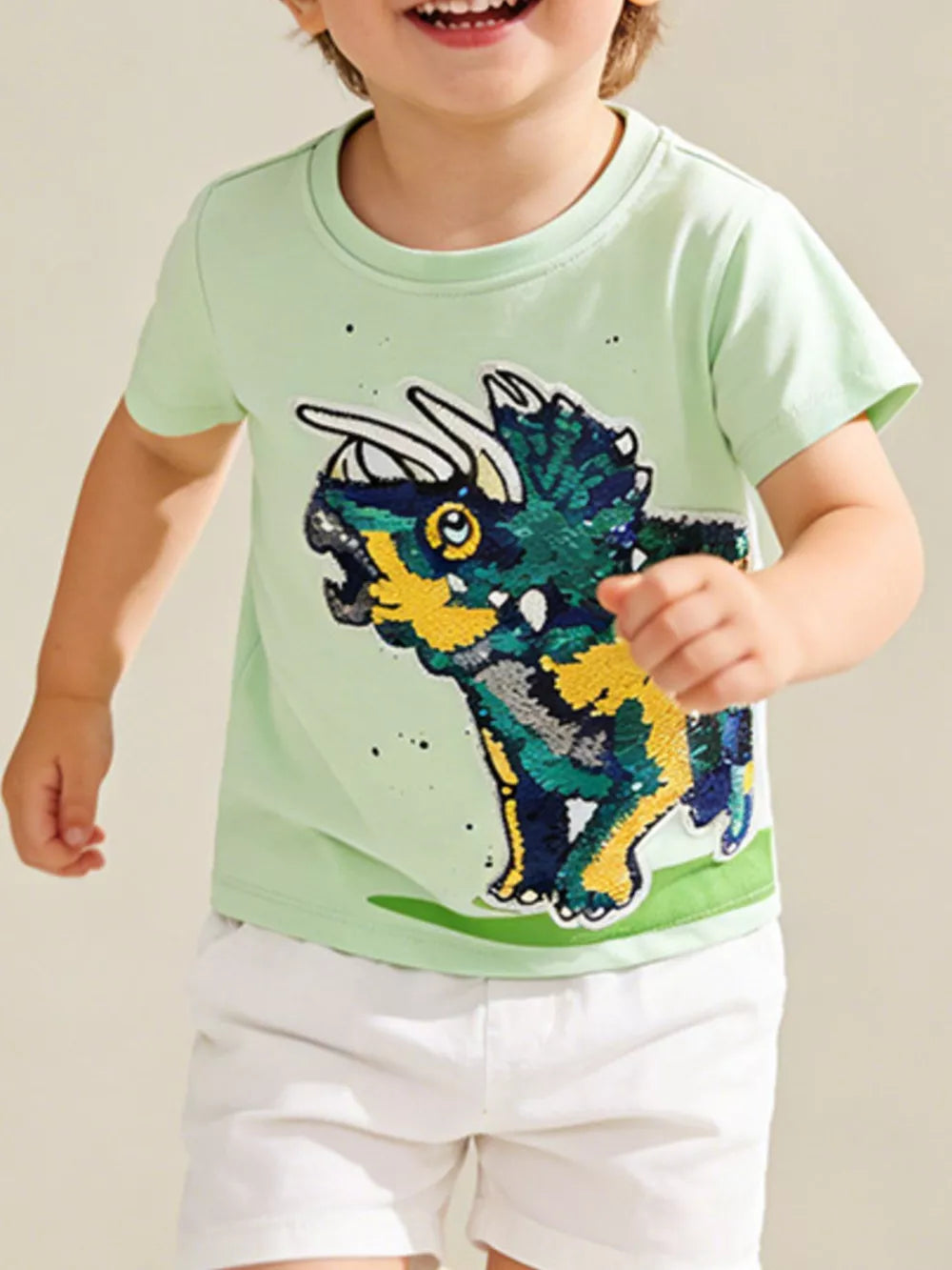 Light green cotton t-shirt with a sparkling dinosaur graphic and short sleeves.