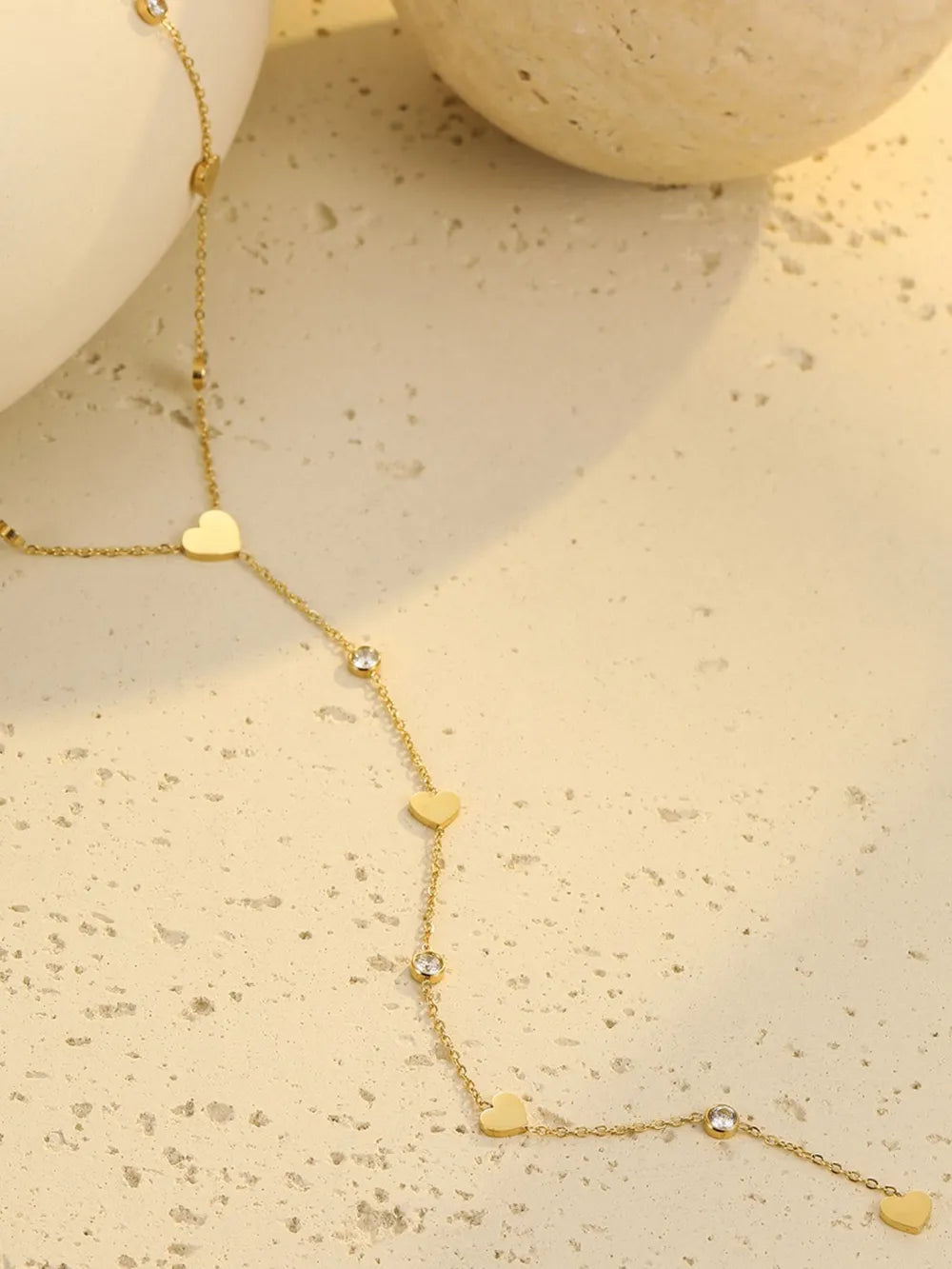 clear necklace featuring heart charms and geometric
