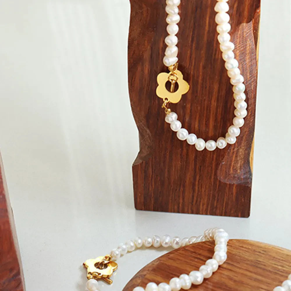 Pearl bracelet with gold flower clasp detail