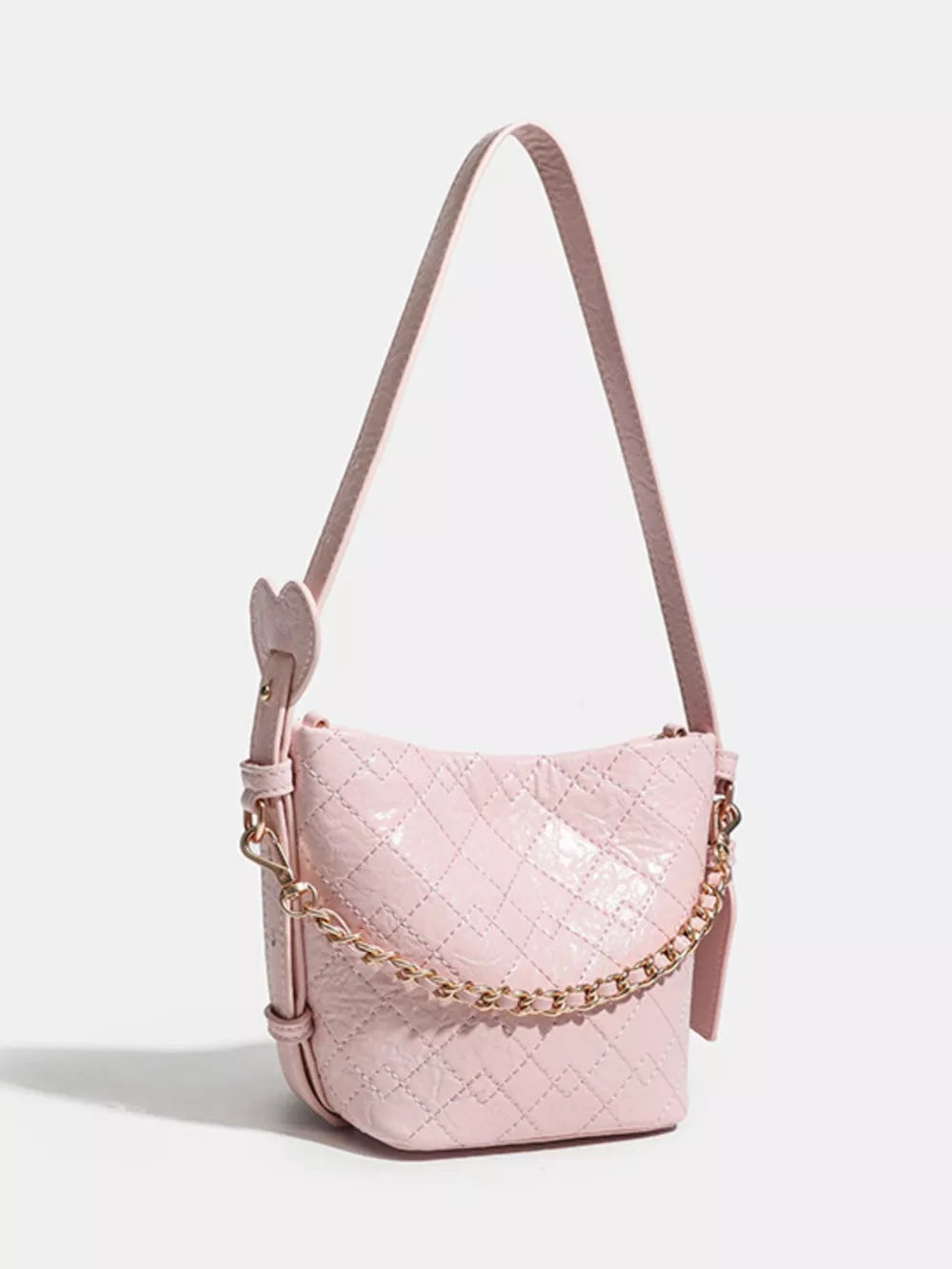 Pink quilted bucket bag with chain accent and heart detail strap