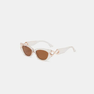 Geometric accent cat-eye sunglasses with clear frames and brown lenses.