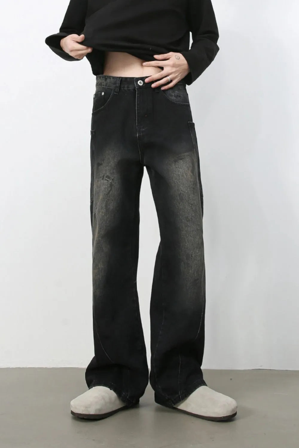 Faded wash wide leg denim jeans in dark, with a relaxed fit and distressed details.