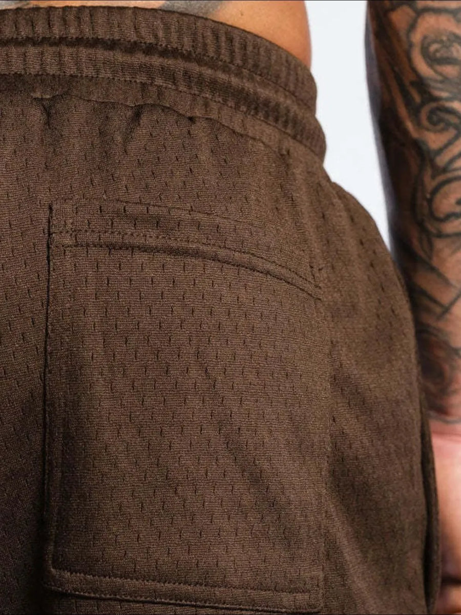 Dark brown perforated performance drawstring shorts with a back pocket detail.