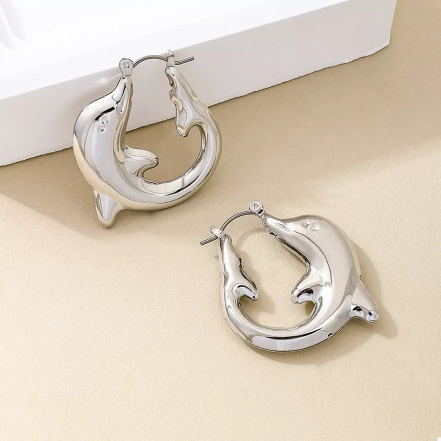 Silver dolphin hoop earrings with a polished finish.