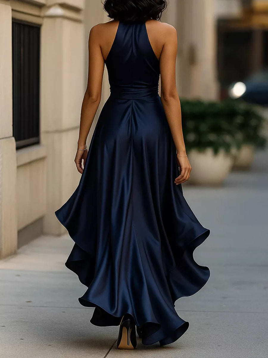 Navy halter maxi dress with ruffled asymmetrical hem and belted waist.