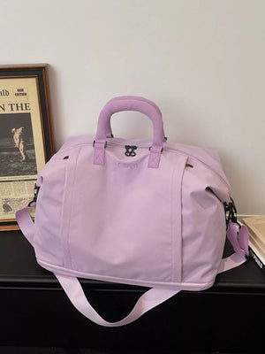 Purple nylon travel bag with adjustable straps and padded handles.