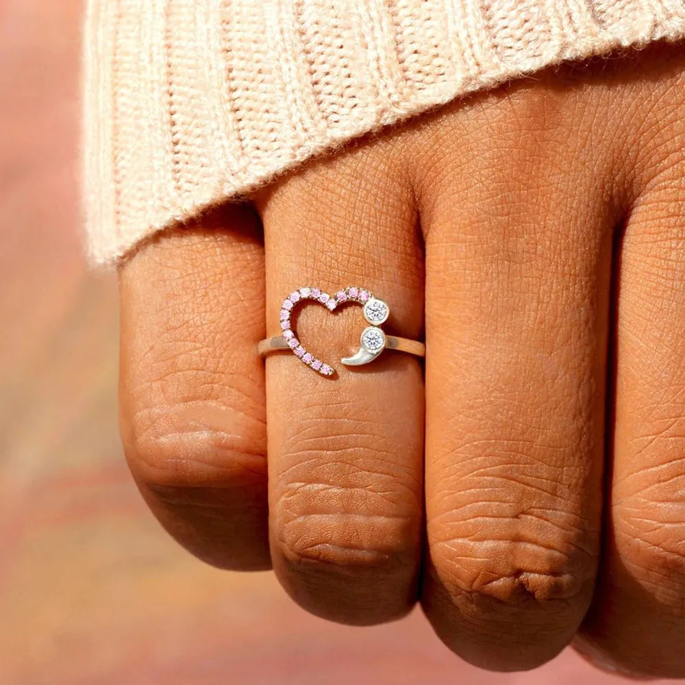 Sterling silver ring with pink heart and semicolon design, featuring clear stones.