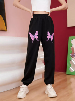 Black sweatpants with pink butterfly embellishments on the front.