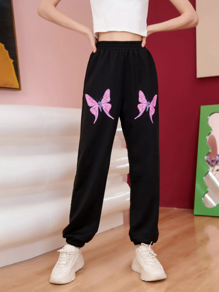 Black sweatpants with pink butterfly embellishments on the front.