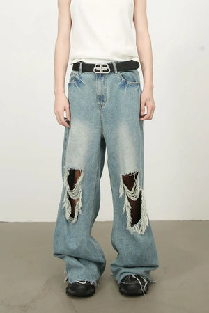 Distressed wide-leg denim jeans in medium wash with fraying and ripped details.