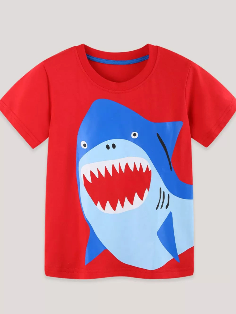 Red cotton t-shirt with a playful blue shark graphic, short sleeves, and crew neck.