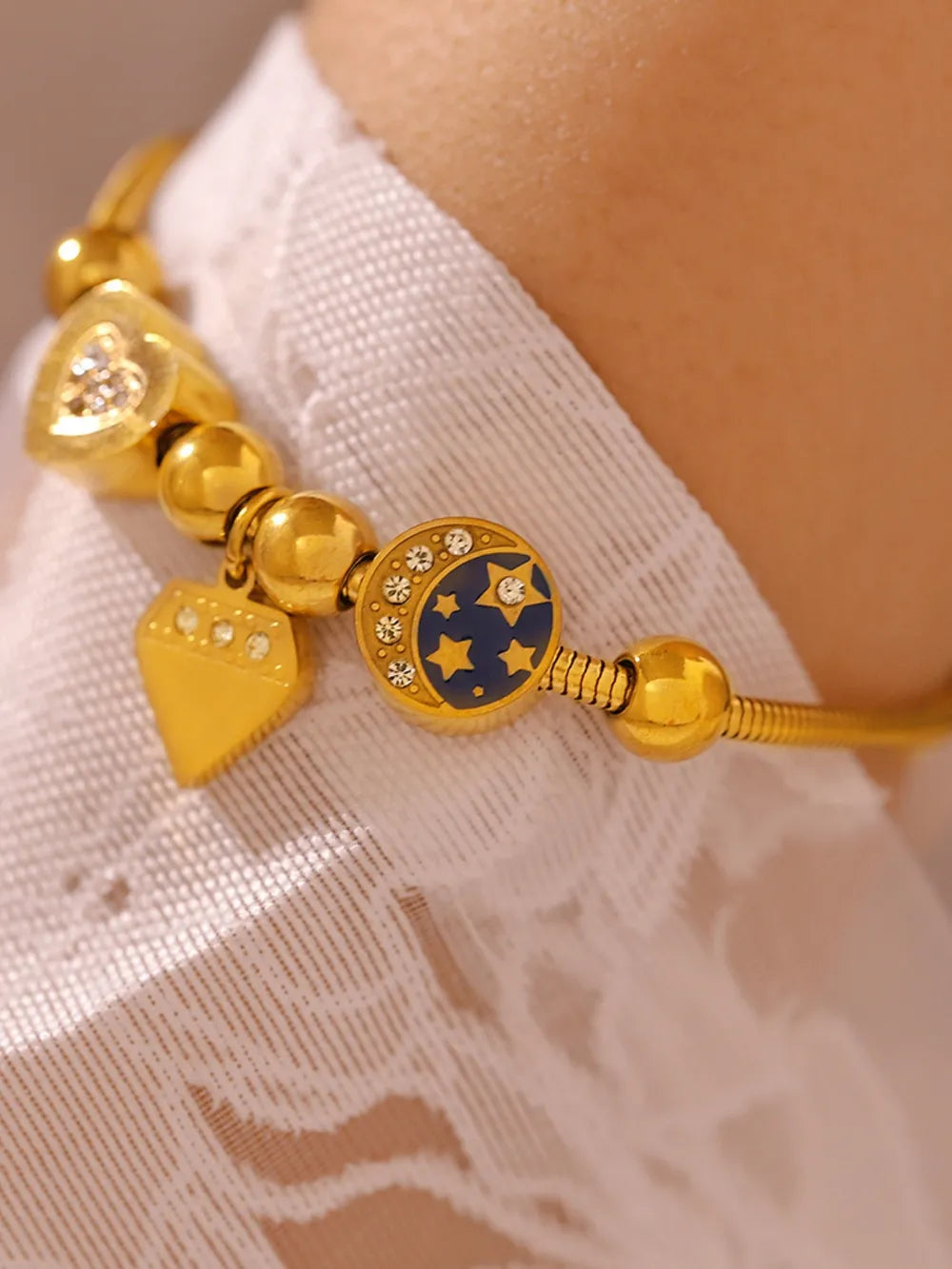 Gold celestial charm bracelet with diamond accents and moon & stars charm