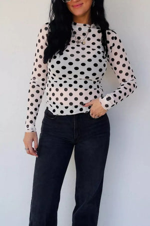 Sheer polka dot mesh mock neck shirt with long sleeves.