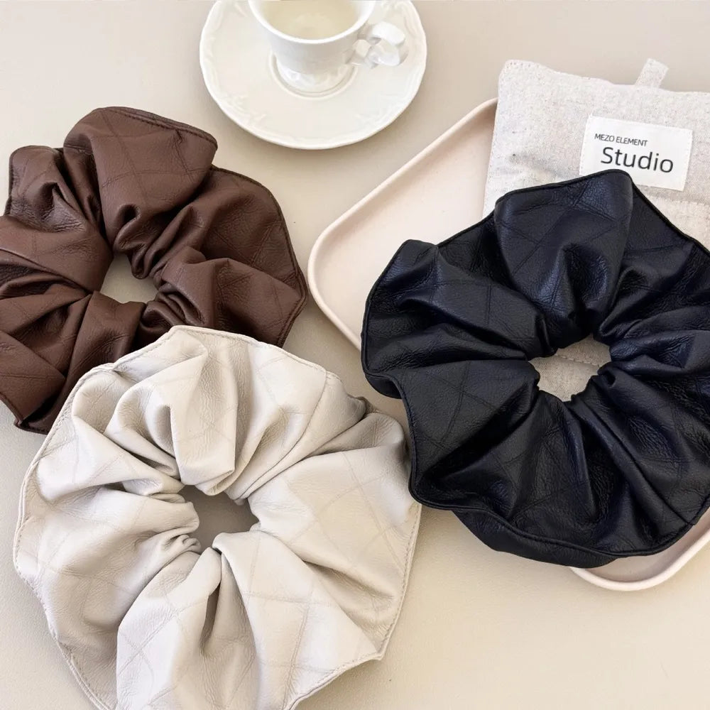 Quilted faux leather scrunchies in beige, brown, and black.