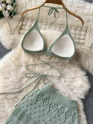 Green crochet halter bikini top with beaded trim and wide-leg pants with diamond pattern.
