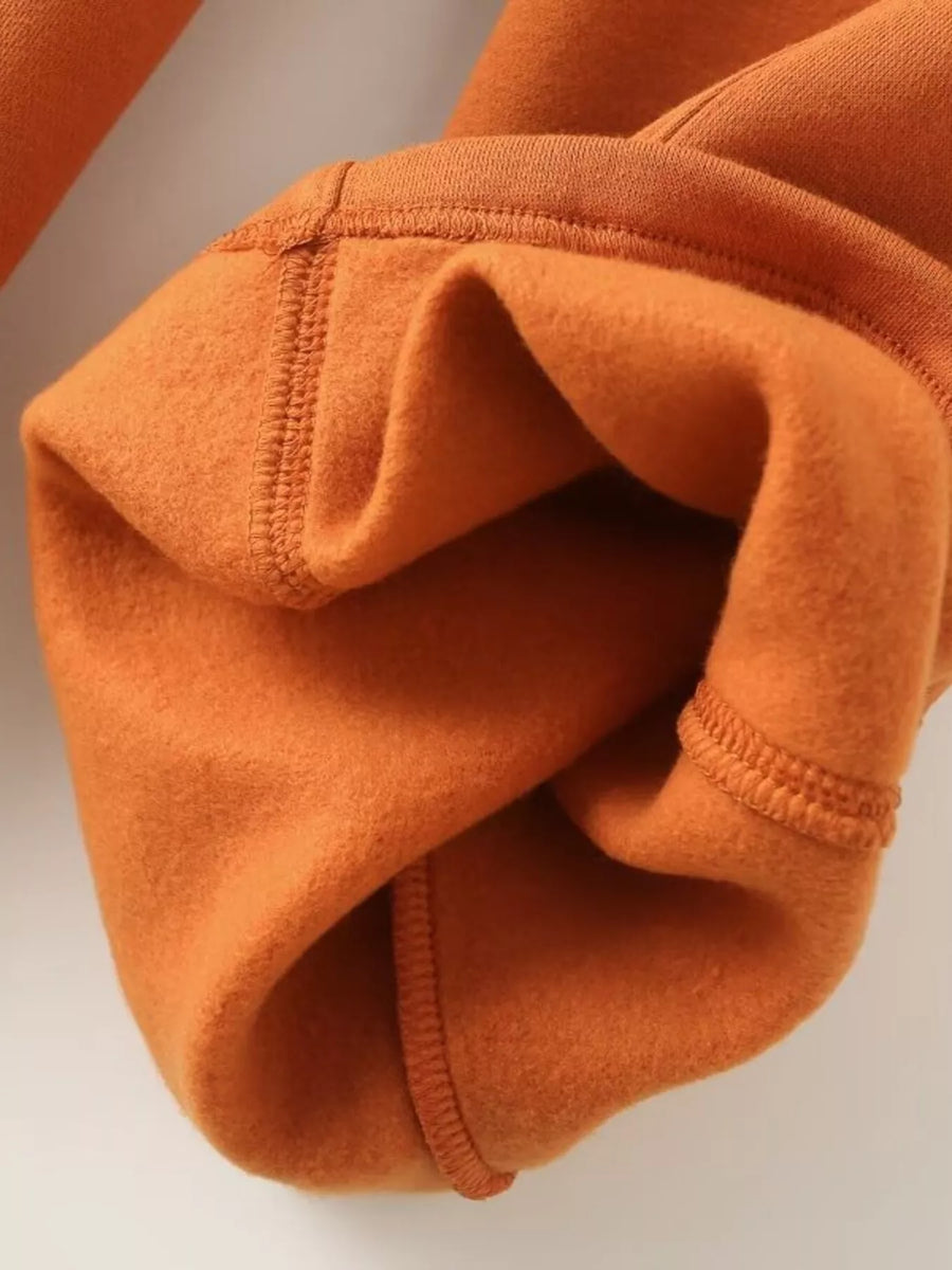 Orange casual zip-up top and wide-leg pants set detail showing soft fleece fabric and stitching.
