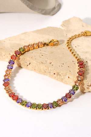 Chromatic zircon tennis bracelet with 18K gold plating and multi-colored gemstones.