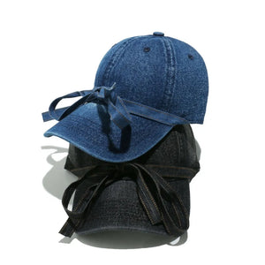 Denim baseball cap in navy and black with a bow tie detail.