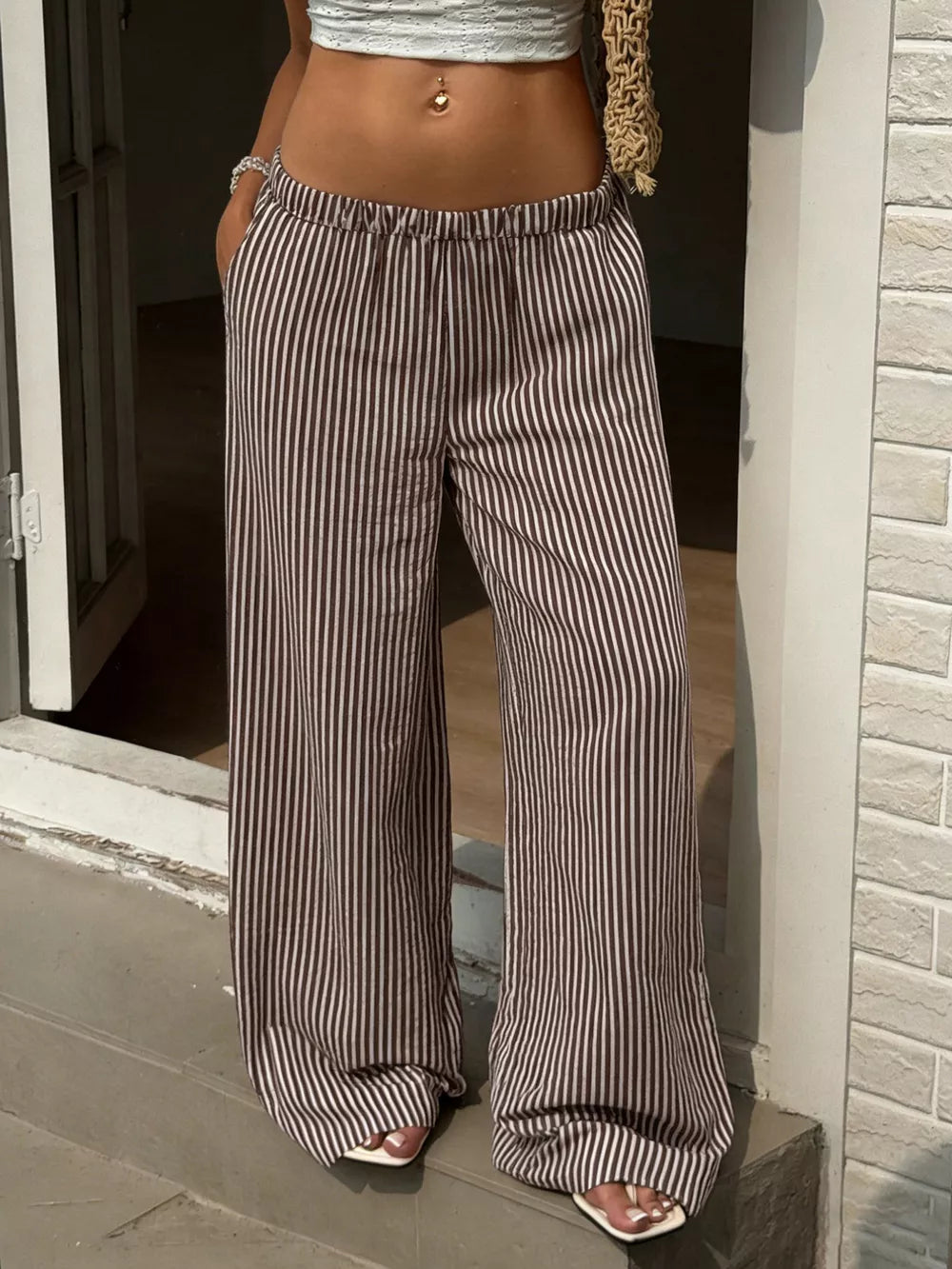 Tied striped wide-leg pants in brown and cream, featuring a comfortable elastic waist.