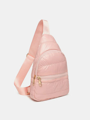 Glossy pink padded sling bag with gold zippers and adjustable strap.