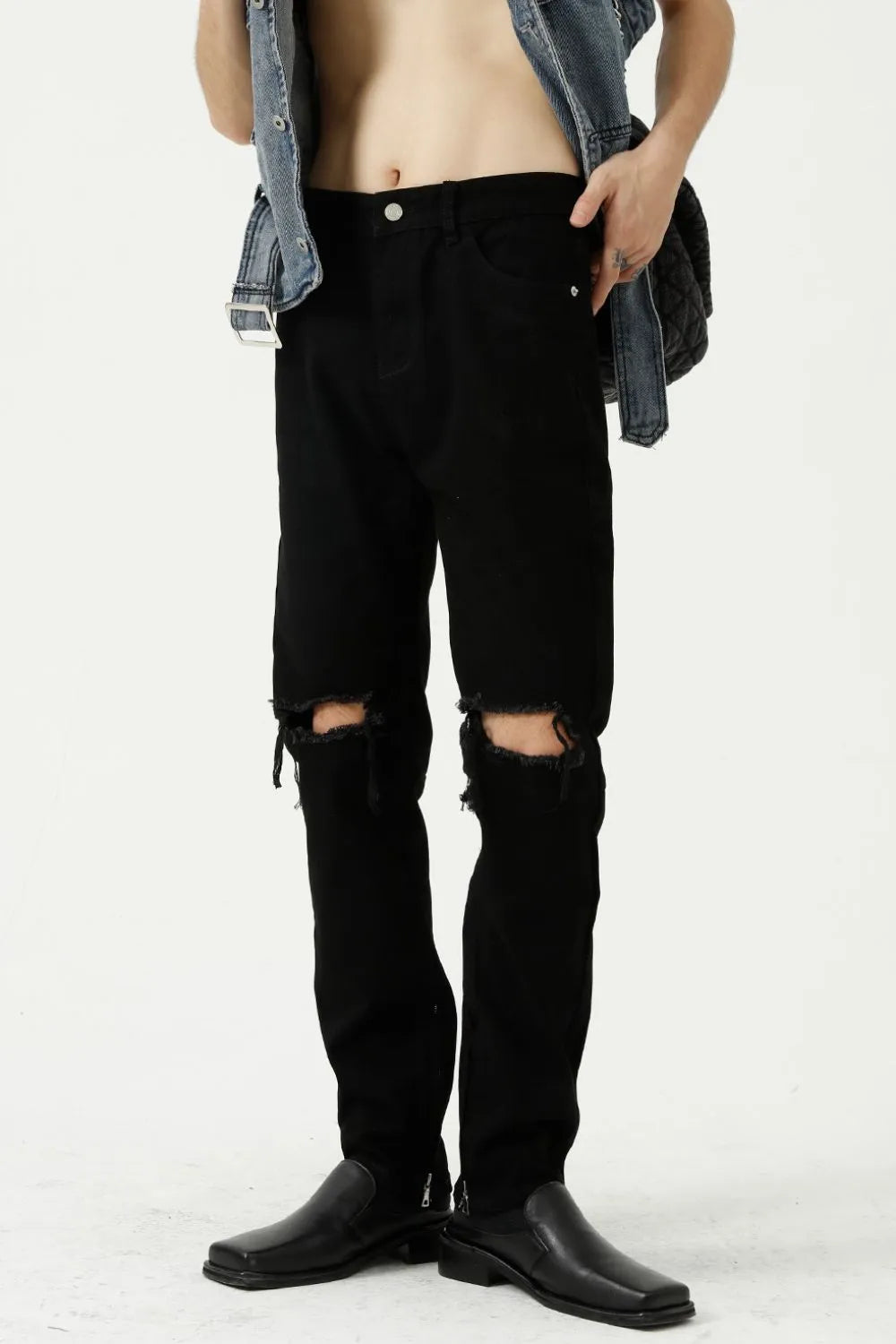 Black denim jeans with distressed knees and a modern straight leg cut.