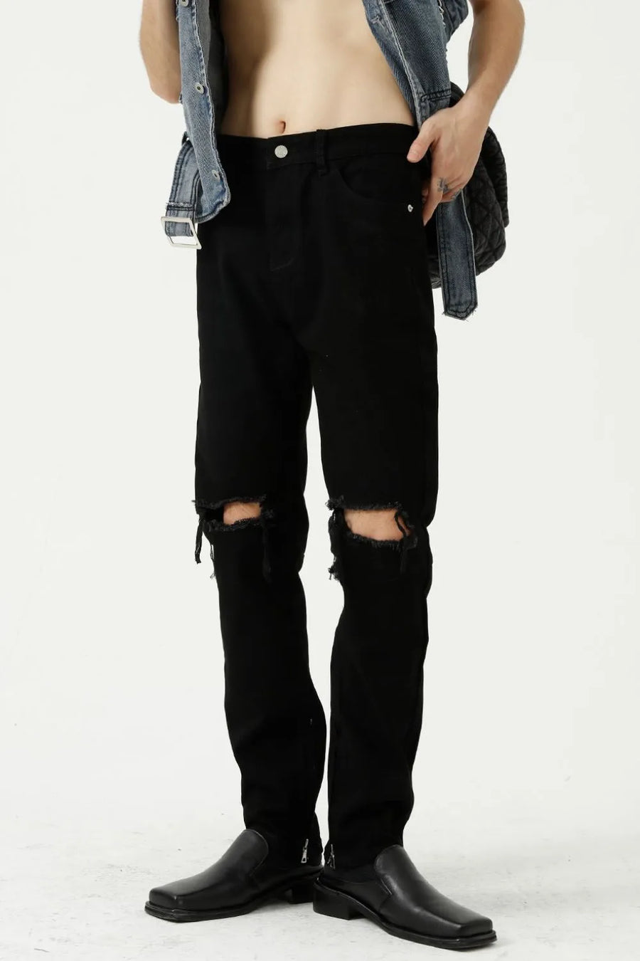 Black denim jeans with distressed knees and a modern straight leg cut.