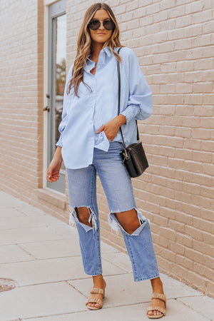 Pastel blue pinstripe blouse with balloon sleeves and button front, styled with jeans.