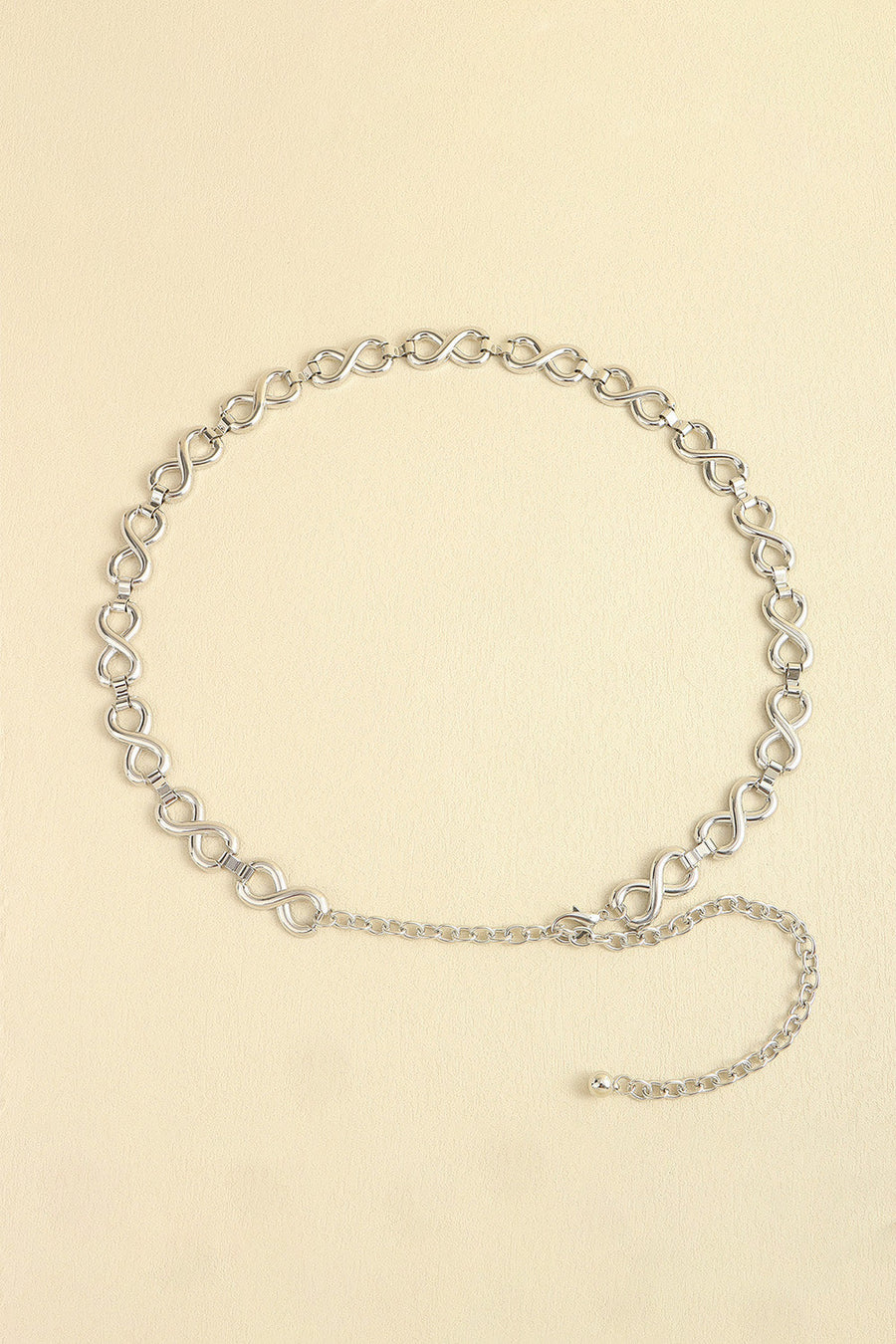 Silver infinity chain belt with adjustable extender and ball end.