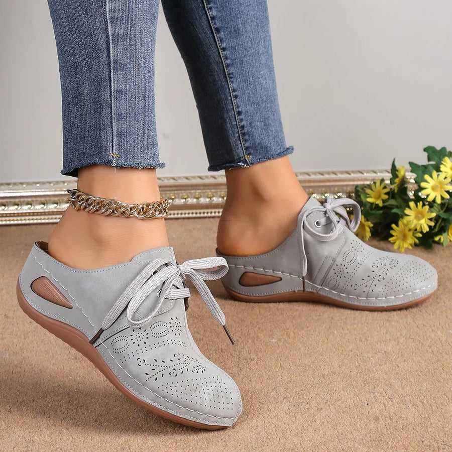 Gray perforated lace-up mule flats with decorative cutouts and a slip-on back.