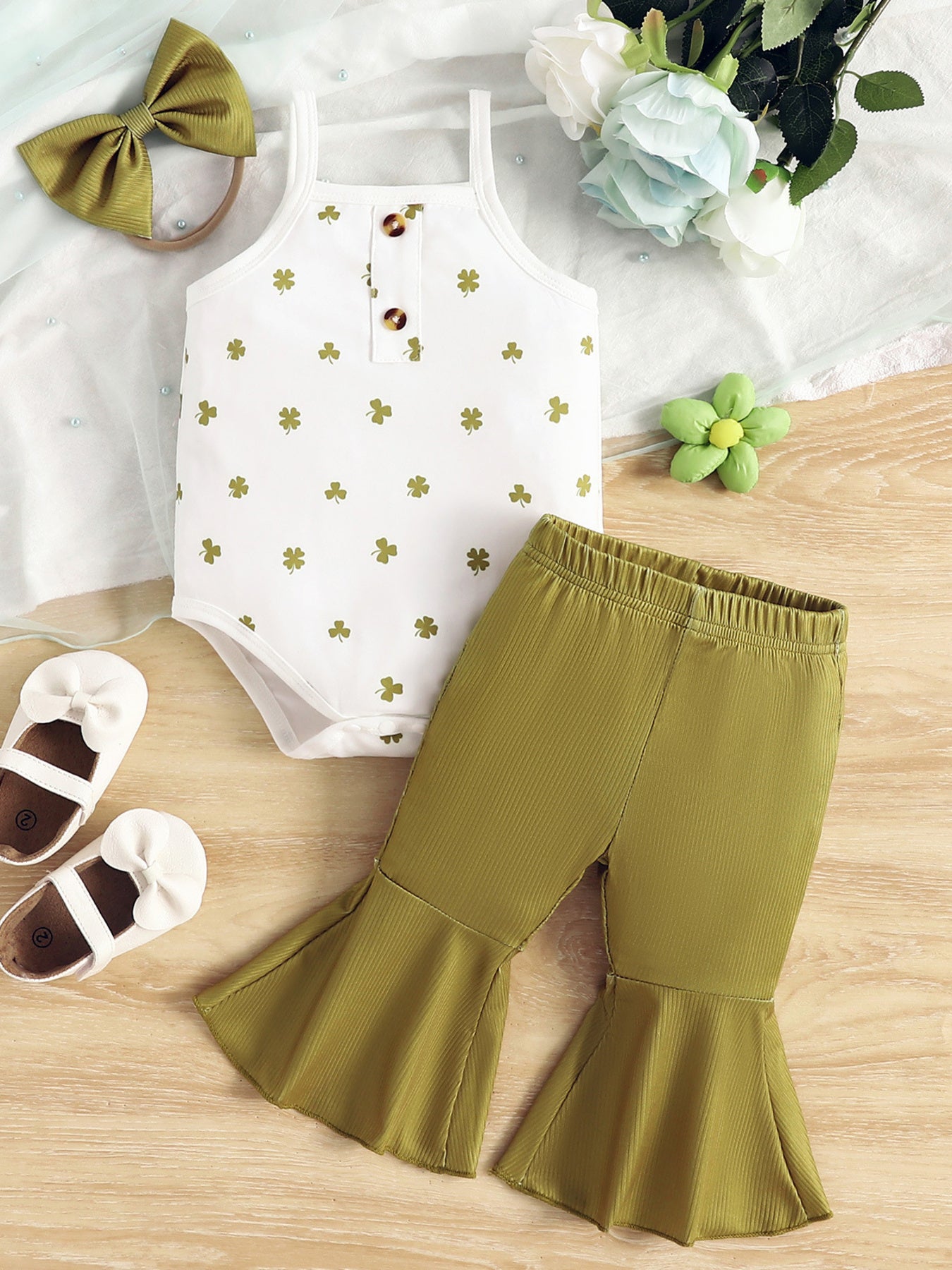 Baby bodysuit with clover print and button detail, paired with flared bell bottom pants in clover green.