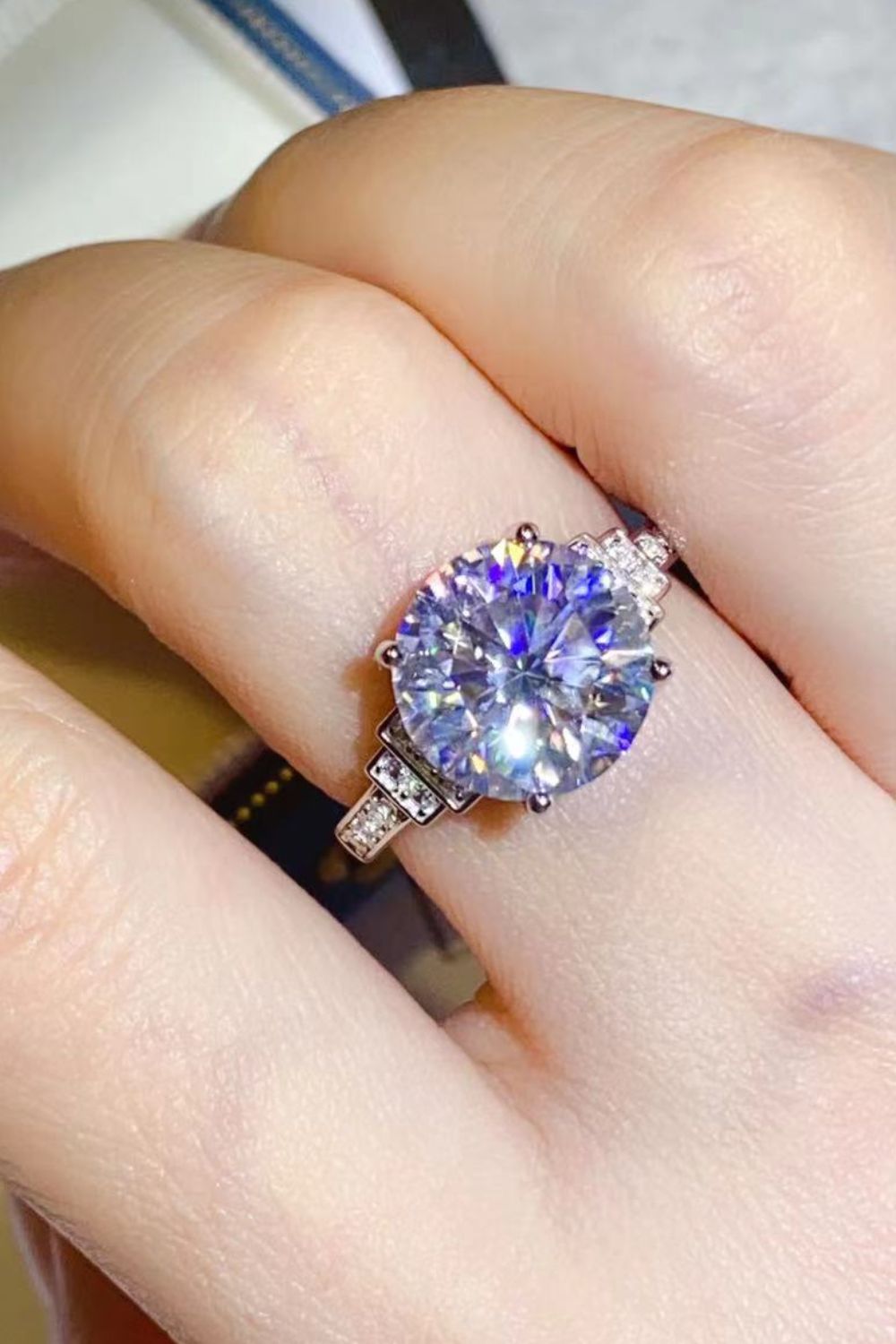 Sterling silver ring with large radiant cut center stone and halo of smaller stones.