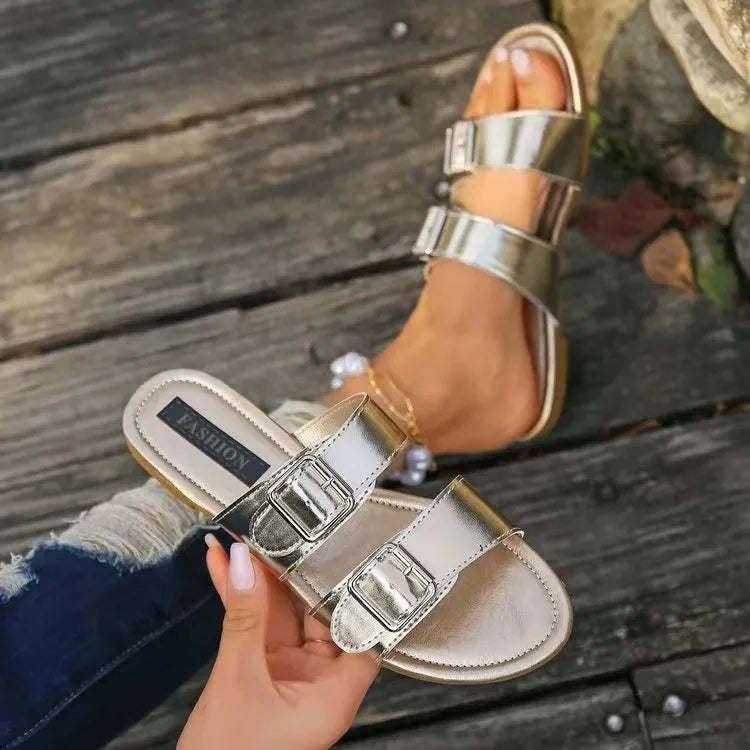 Metallic buckle slide sandals in silver with double straps and adjustable buckles.