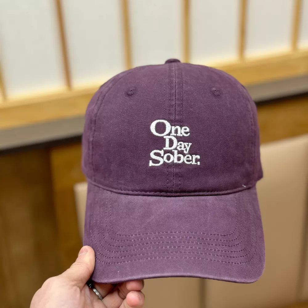 Purple cotton baseball cap with distressed finish and white embroidered text.