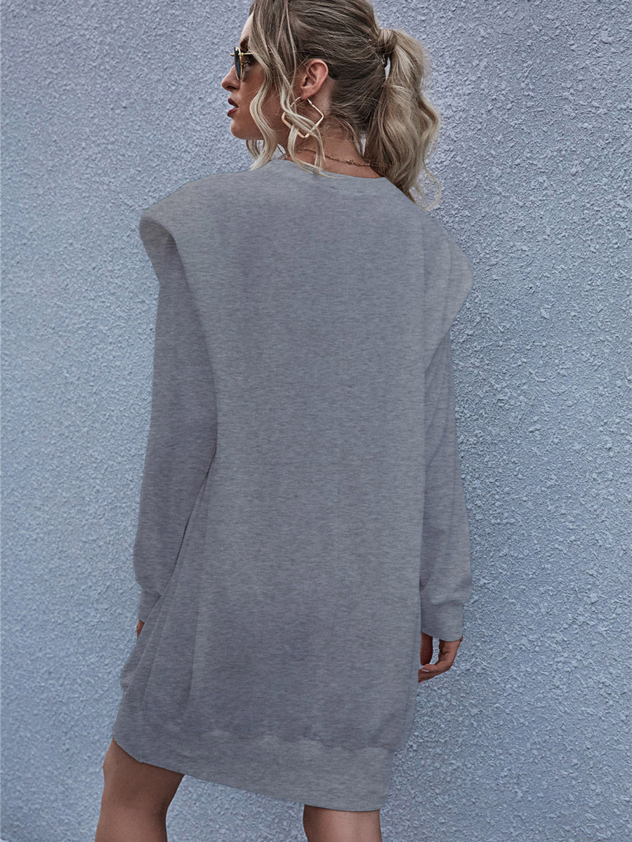 Grey sweatshirt mini dress with padded shoulders and long sleeves.
