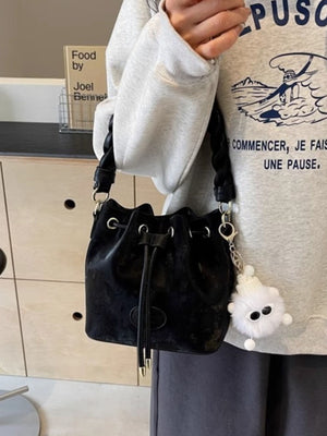 Black velvet bucket bag with chunky chain trim and fuzzy charm