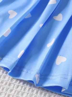 Blue baby dress with white heart print and pleated hem detail.