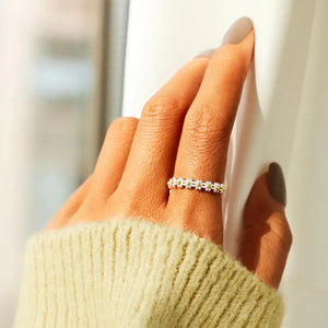 Silver band ring with a daisy chain pattern and gold bead accents.
