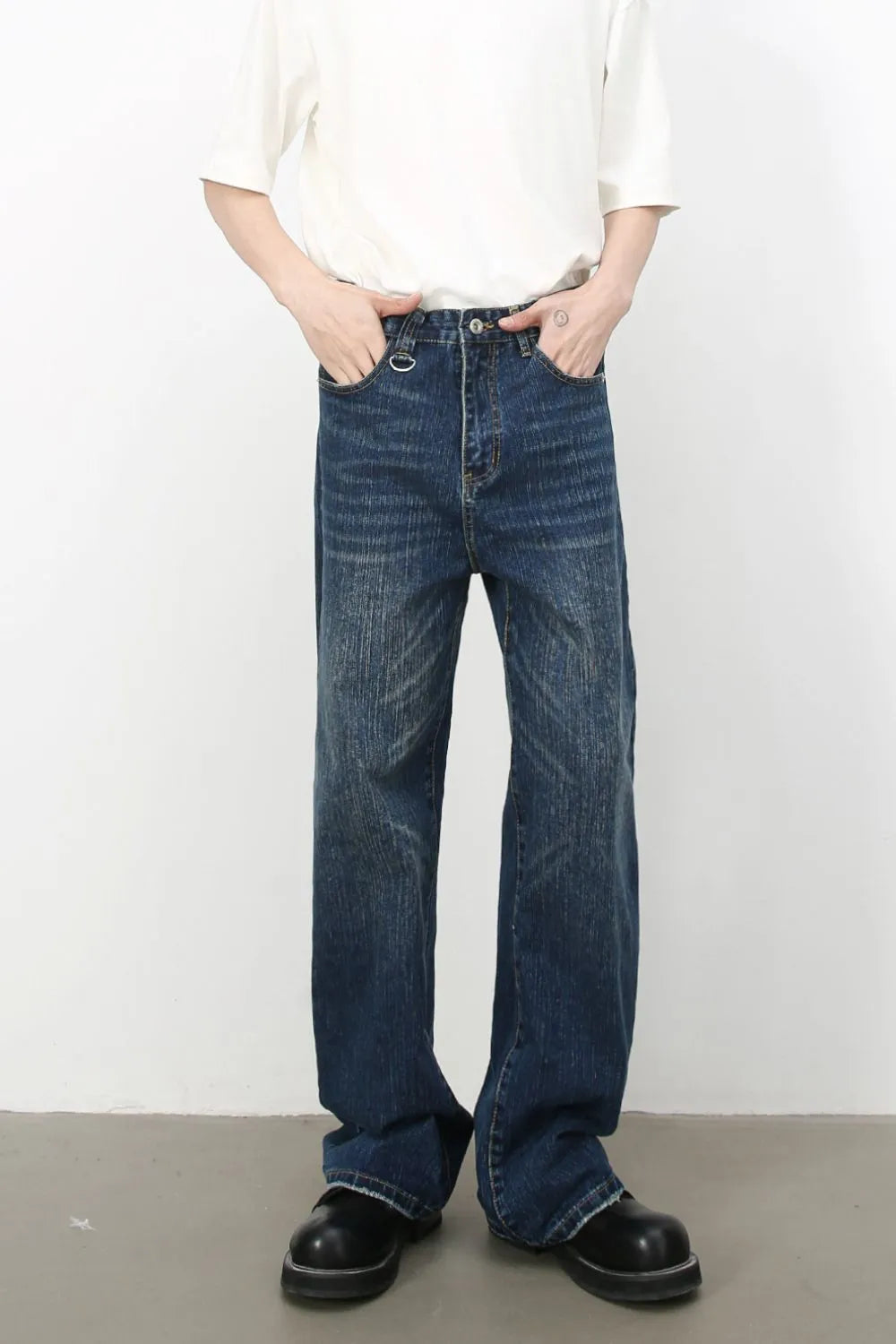 Wide leg distressed denim jeans in dark wash, featuring whiskering and a casual fit.