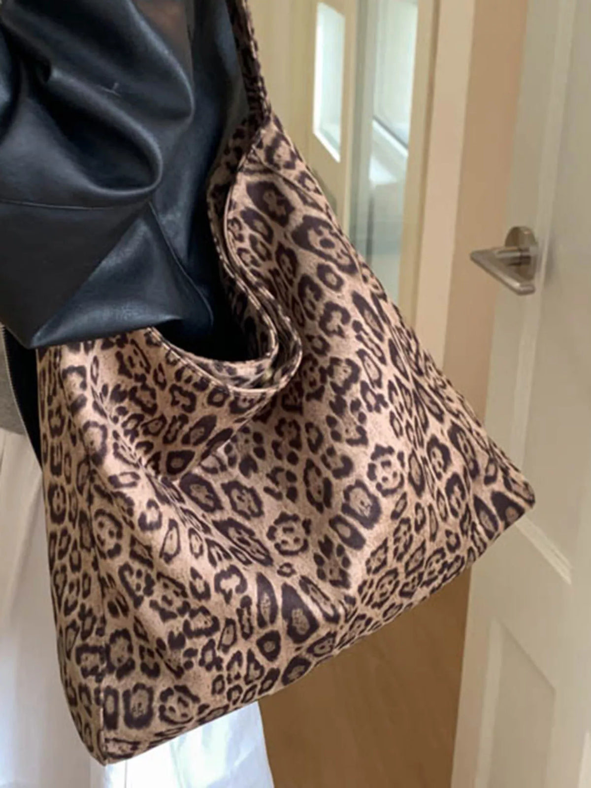 Stylish leopard print tote bag in khaki with a slouchy design and black faux leather trim.