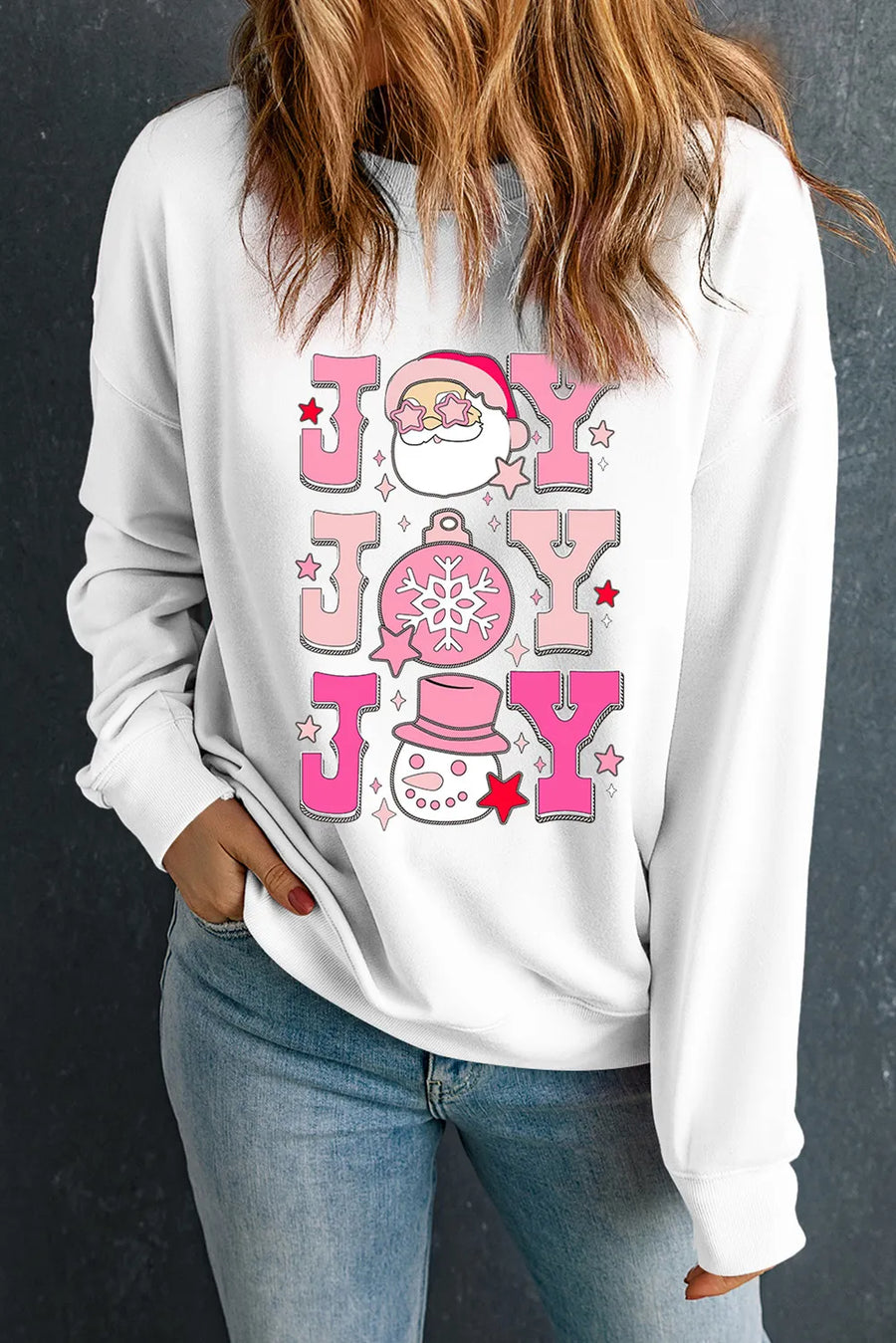 White crewneck sweatshirt with pink JOY graphic featuring Santa, ornament, and snowman.