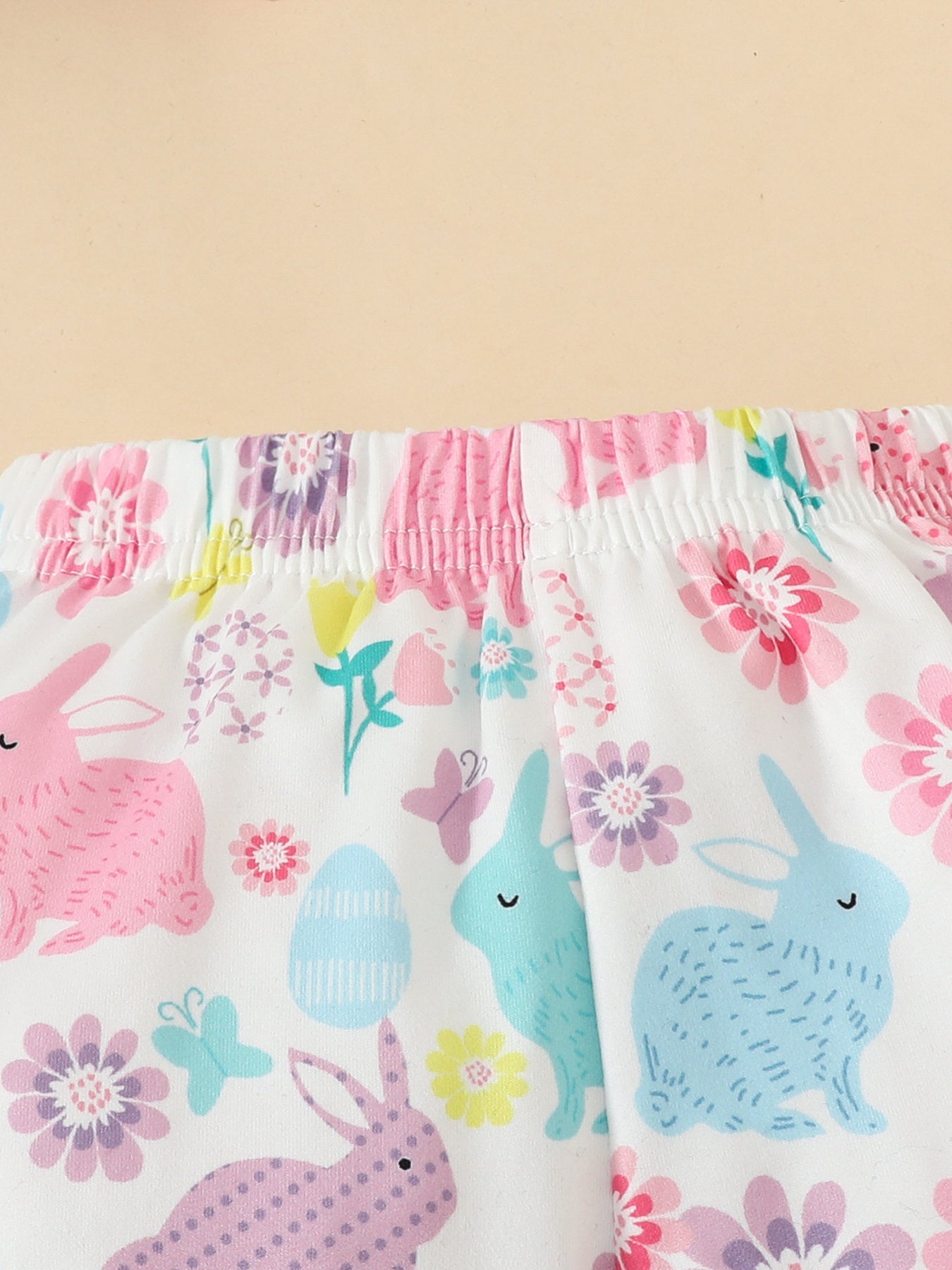 Baby set with white fabric, pink and blue bunnies, flowers, and Easter eggs pattern.