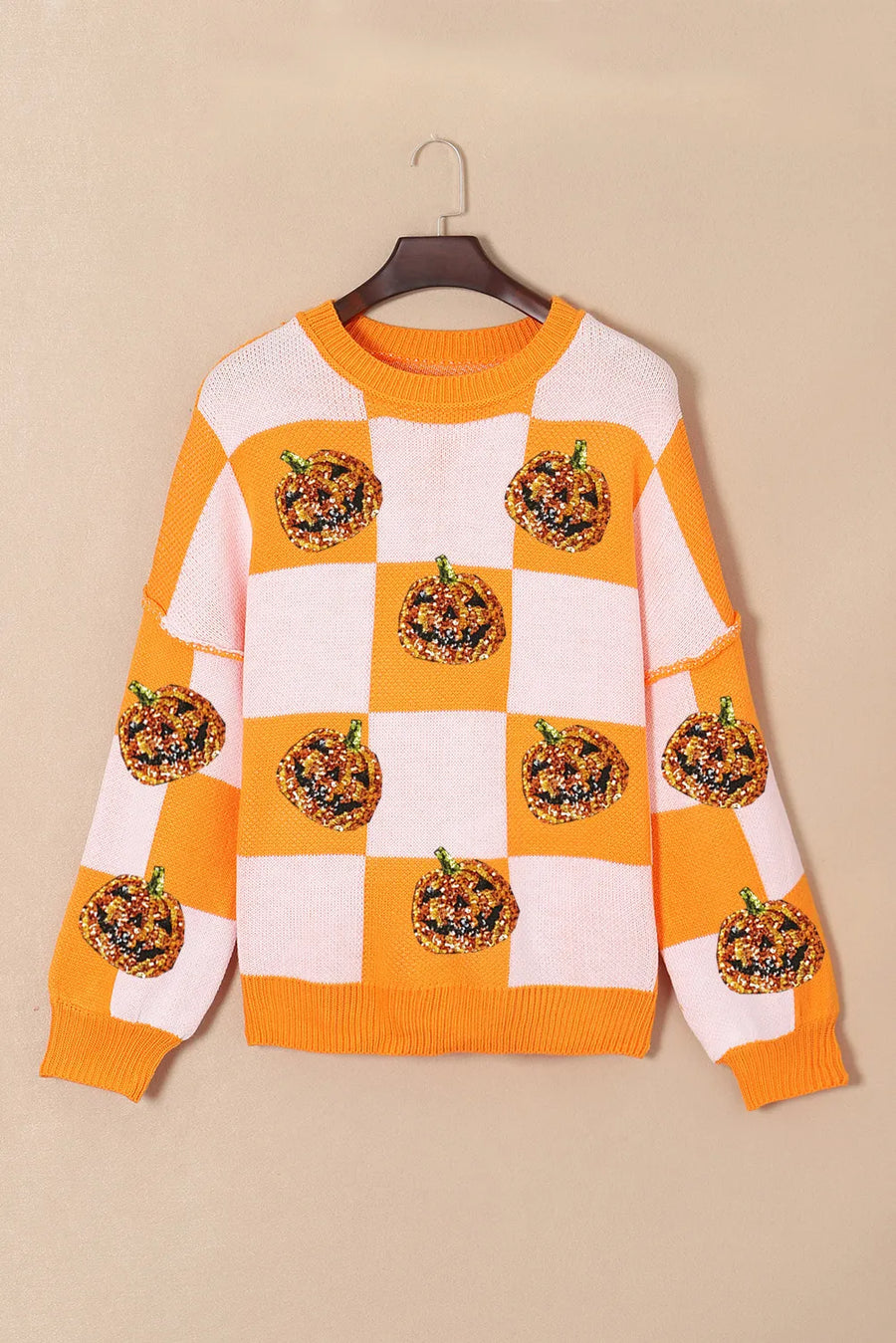 Checkerboard pumpkin appliqué knit sweater in tangerine with crew neck and long sleeves.