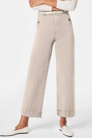 Wide-leg tan denim trousers with buttoned pockets and a white belt.