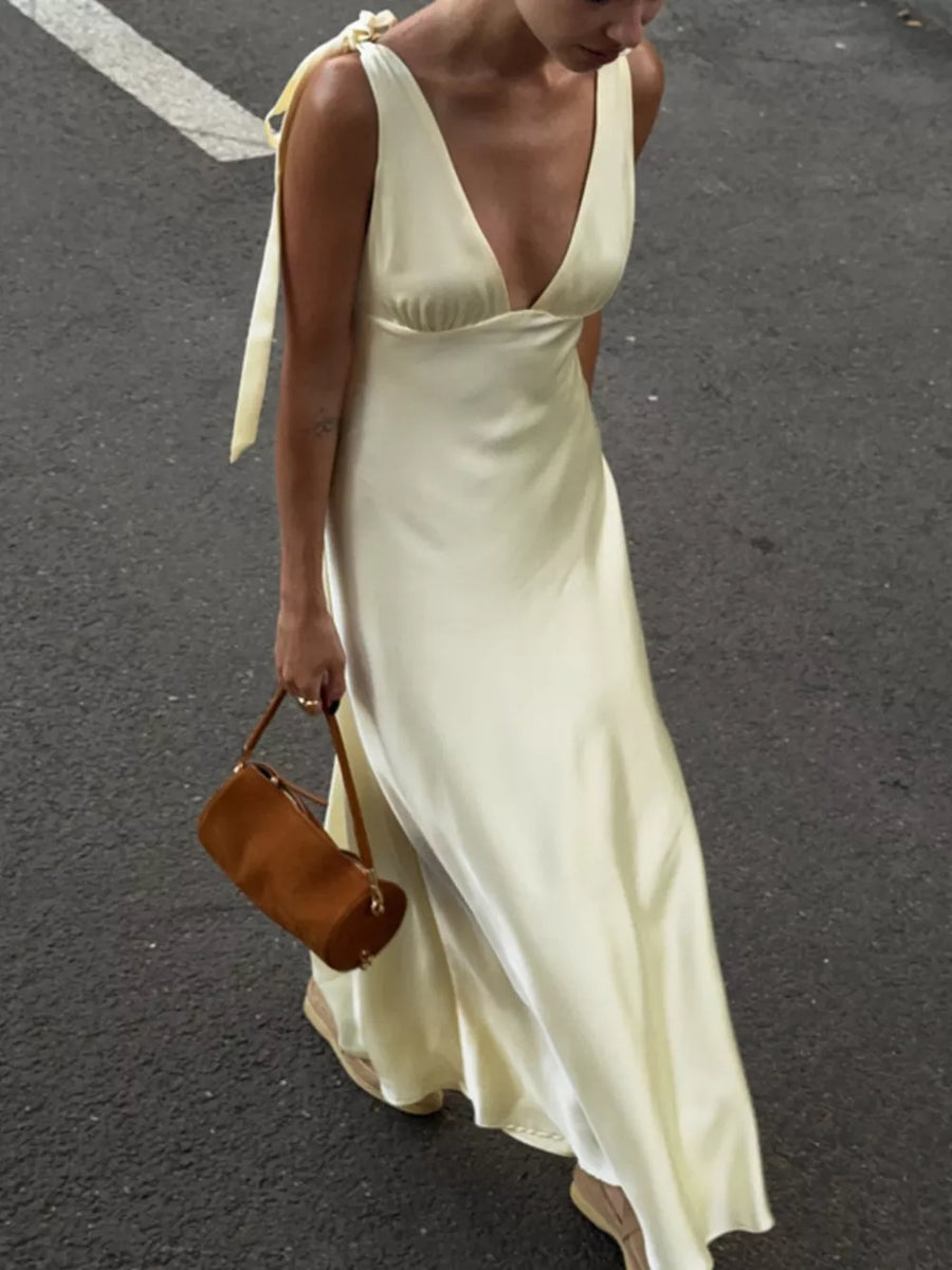 Satin slip dress in pale yellow with deep V-neck and tie shoulder straps.