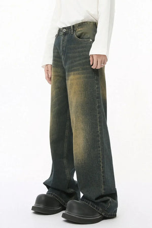 Faded wash balloon leg jeans in a distressed muddy denim color with a relaxed fit.