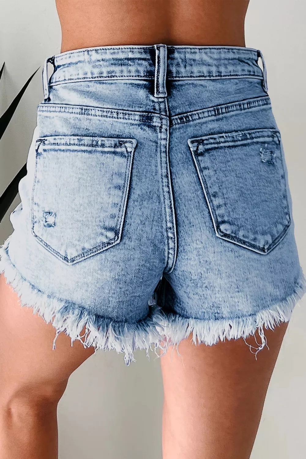 Acid wash denim shorts with distressed details and frayed hem