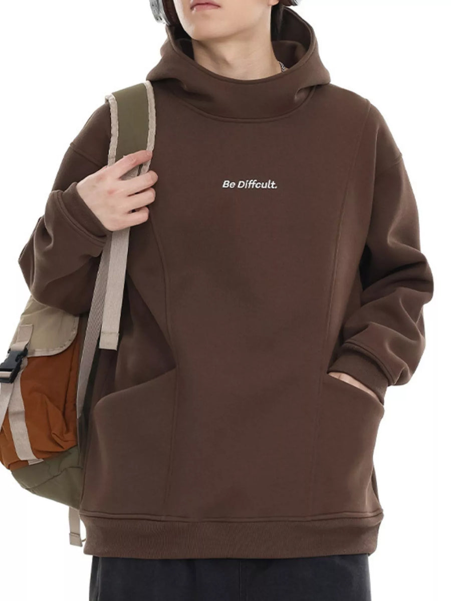 Oversized brown hoodie with subtle white text graphic and kangaroo pocket.