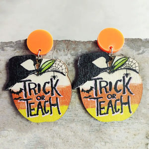 Spooky teacher apple earrings with orange acrylic tops and "Trick or Teach" text.