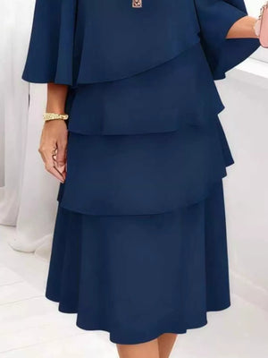 Dark blue tiered dress with 3/4 sleeves and ruffled layers.